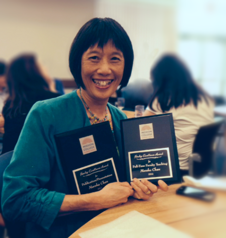 Marsha Chan holding up two plaques from Mission College